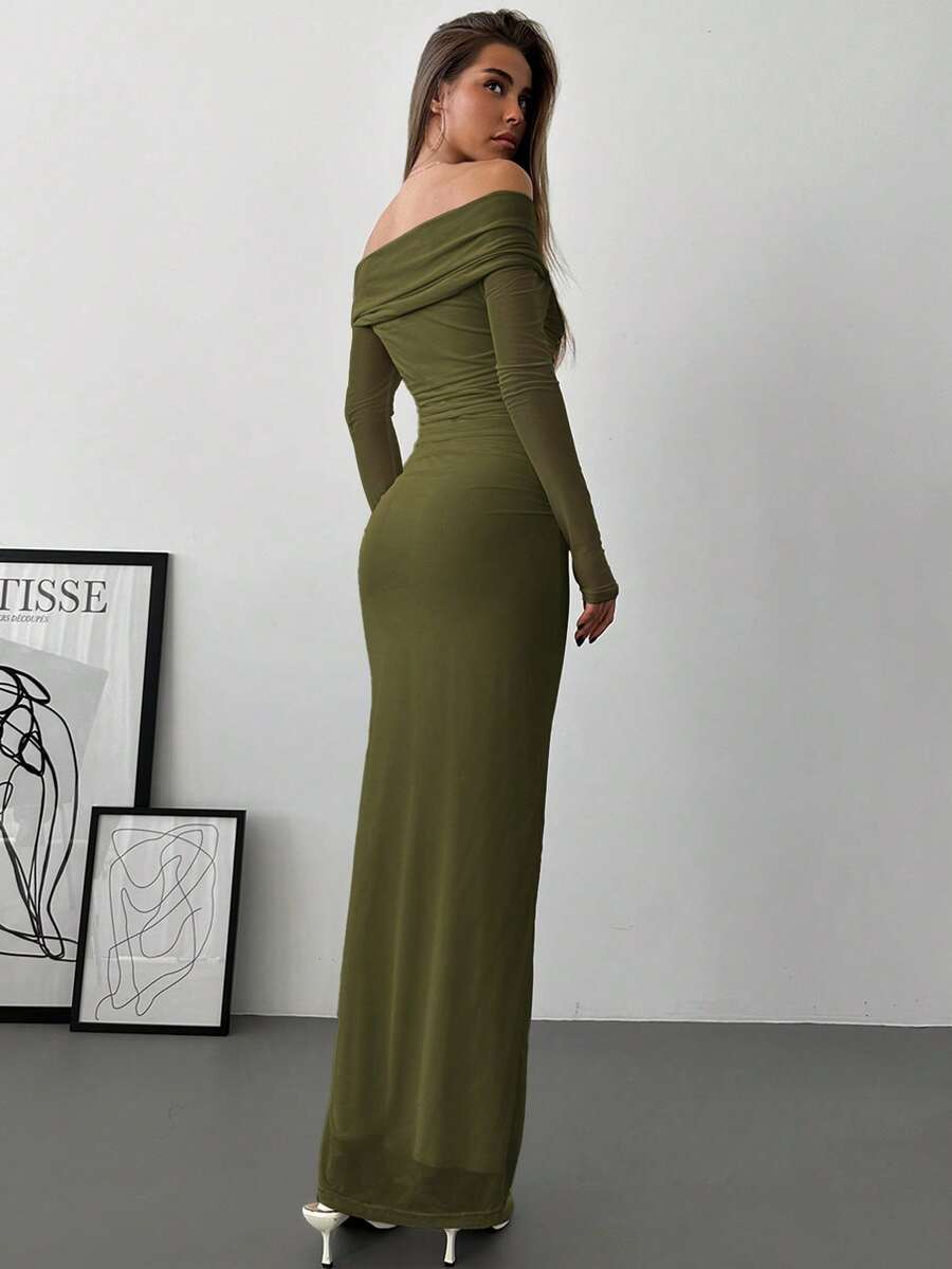 Mujer posando con un vestido largo ajustado color verde olivo de hombros descubiertos.