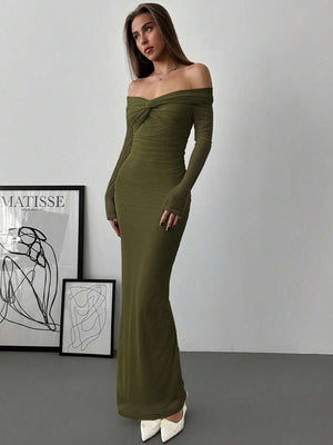 Vista de perfil de la falda larga de un vestido verde olivo y zapatos de punta blancos.