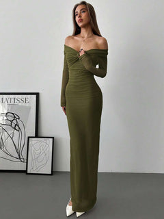 Mujer posando con un vestido largo ajustado color verde olivo de hombros descubiertos.