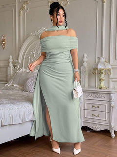Mujer con vestido largo elegante color verde menta posando en una habitación.