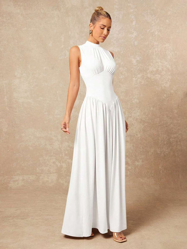 Look completo de vestido maxi blanco sin mangas combinado con sandalias de tacón y aretes dorados