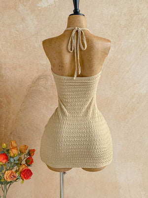 Primer plano del top halter del vestido beige con detalle de aro, estrella de mar y conchas.