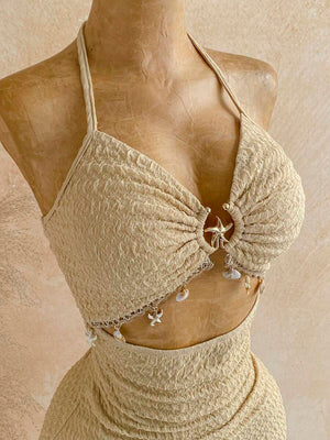 Vista lateral de la falda mini texturizada de talle alto del conjunto beige.
