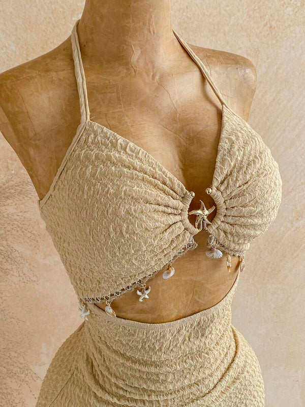Vista lateral de la falda mini texturizada de talle alto del conjunto beige.