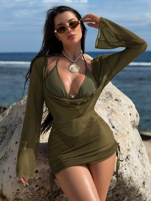 Mujer posando en una roca junto al mar con un conjunto playero de tres piezas en color verde militar.
