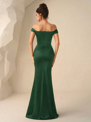 Primer plano del busto de un vestido verde con hombros descubiertos y detalles fruncidos.