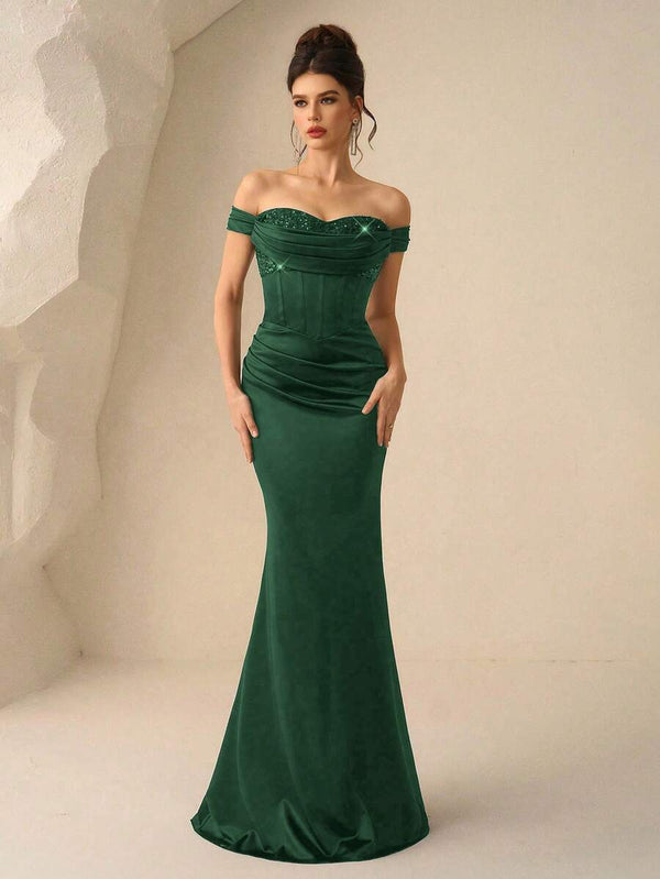 Modelo luciendo un elegante vestido de fiesta verde con corsé y falda tubo.