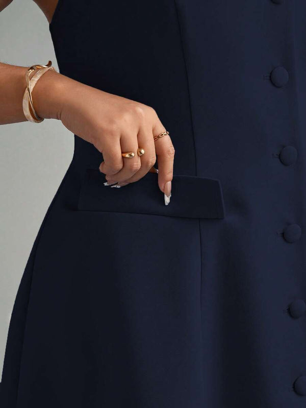Detalle lateral de la falda con vuelo y el bolsillo con solapa de un vestido azul marino.