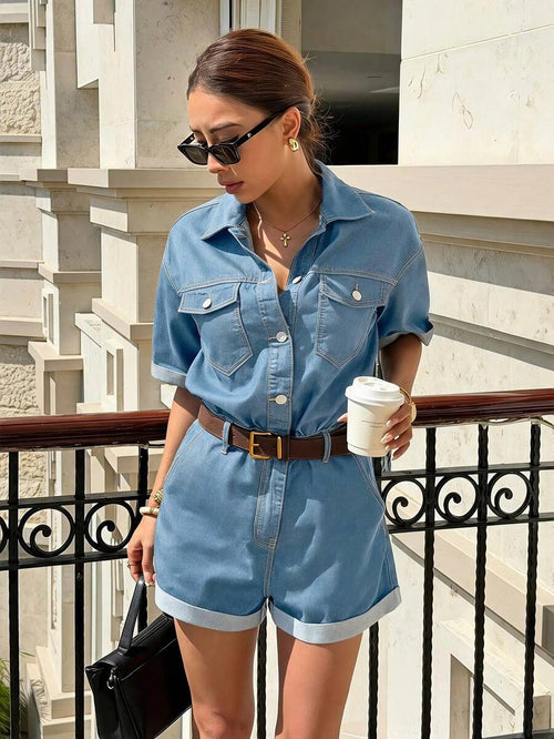 Mujer modelando un romper de mezclilla azul claro con botones, cinturón café y lentes de sol en un balcón.
