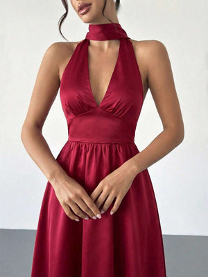 Una mujer luciendo un vestido rojo elegante con zapatos de tacón color nude.