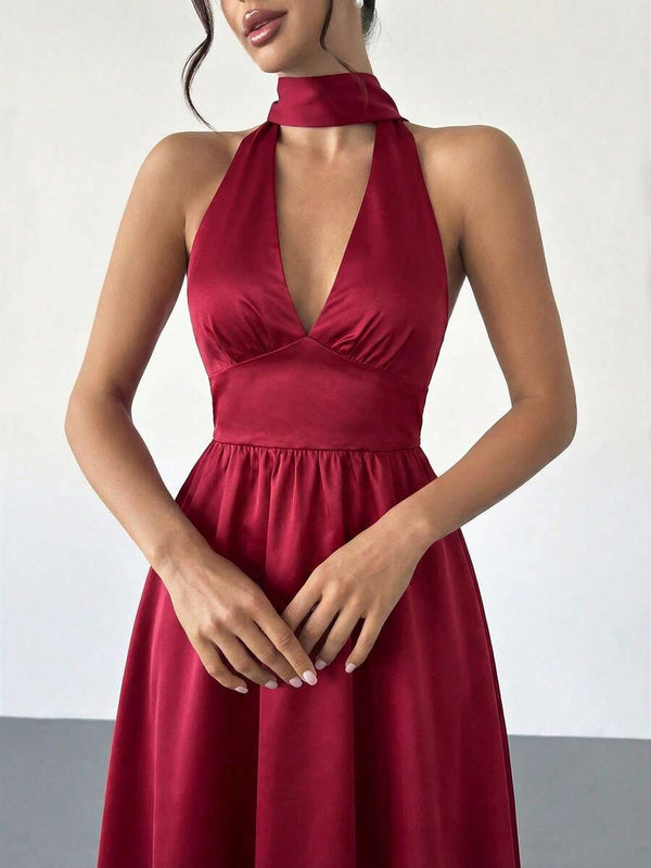 Una mujer luciendo un vestido rojo elegante con zapatos de tacón color nude.