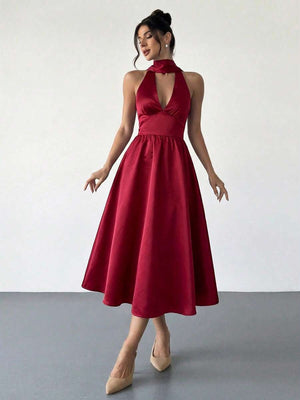 Mujer elegante posando con un vestido rojo de satén con cuello halter y falda midi.