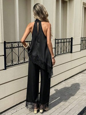 Primer plano del top halter negro de satín con cuello alto y espalda descubierta.