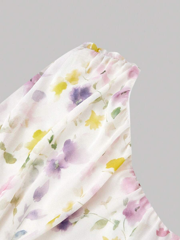 Primer plano de la tela de un vestido con estampado de pequeñas flores en tonos pastel sobre fondo blanco.