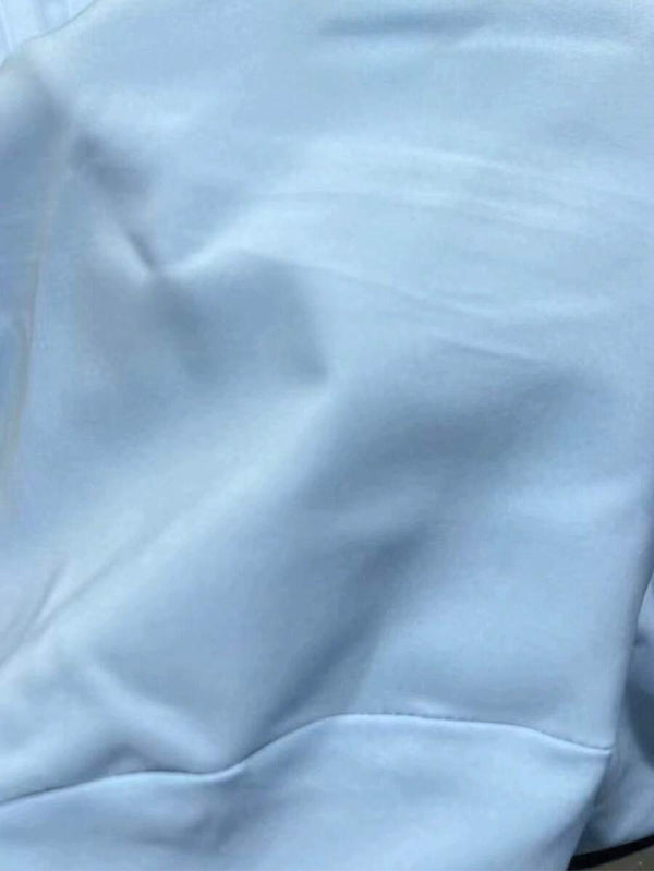 Detalle de la falda corta con doble capa de volantes de un vestido azul.