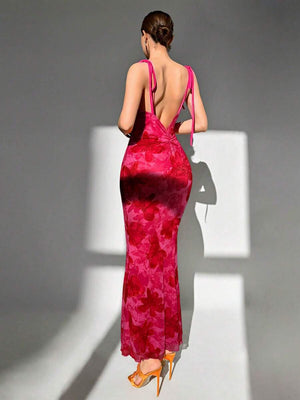 Vista trasera de un vestido largo floral fucsia con espalda completamente descubierta y tirantes finos.