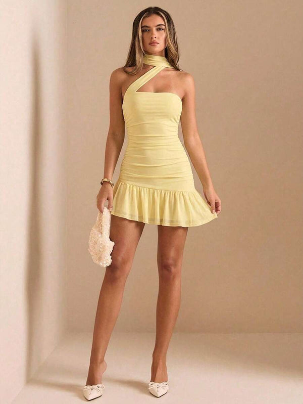 Detalle del diseño asimétrico del escote halter y el fruncido en la cintura del vestido corto color amarillo.