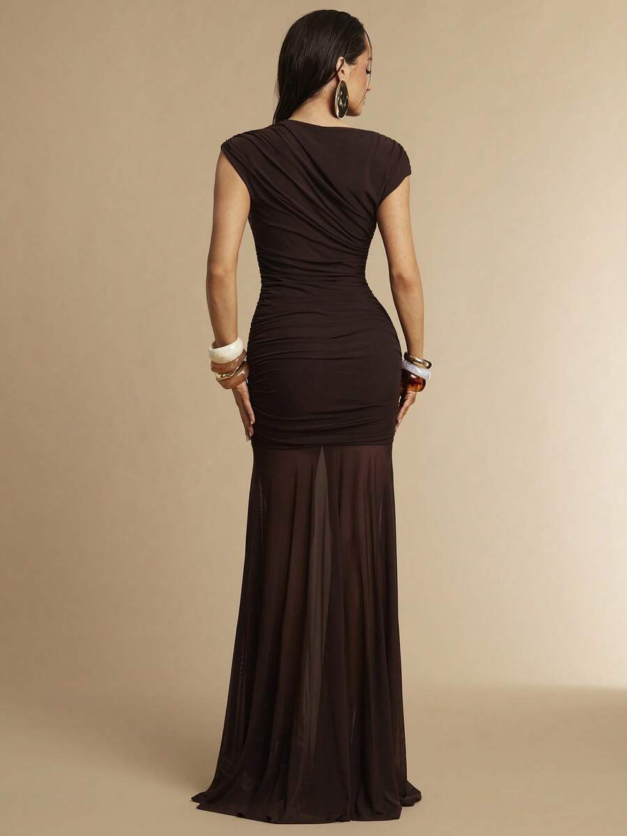 Vista completa de modelo usando un vestido largo marrón de un solo hombro con detalle fruncido y falda de malla transparente.