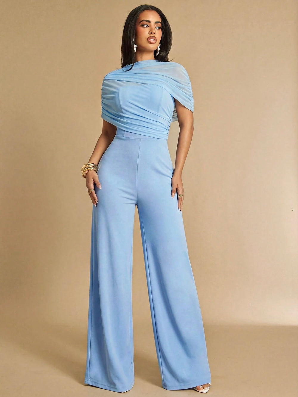 Jumpsuit elegante celeste de pierna ancha con cuello alto y manga capa drapeada vista frontal
