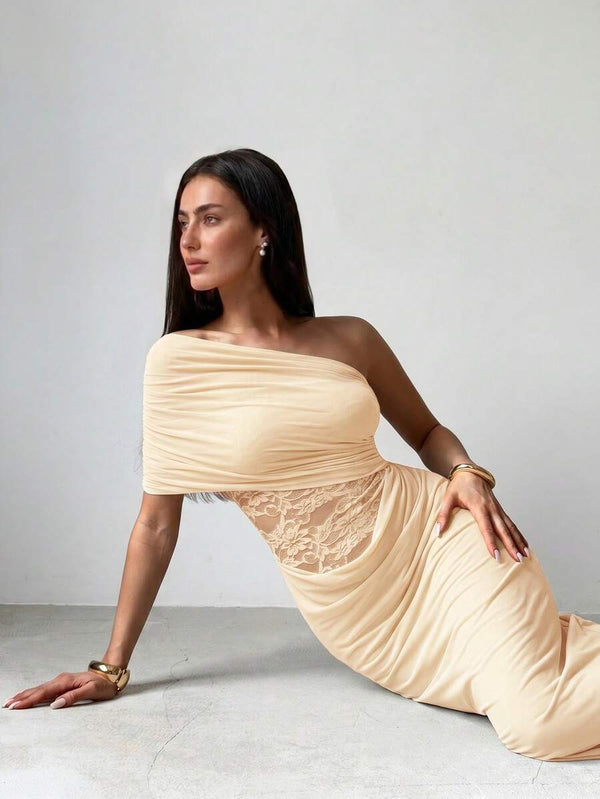 Mujer luciendo un elegante vestido largo color champán con corte de un solo hombro y fruncido en el cuerpo.