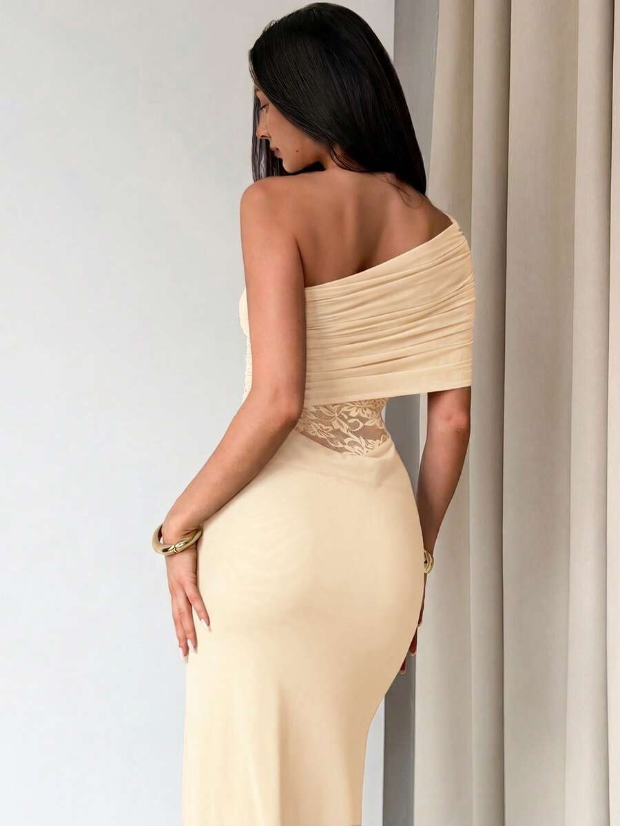 Vista completa de un vestido largo beige asimétrico con un hombro descubierto y detalle de encaje en la cintura.