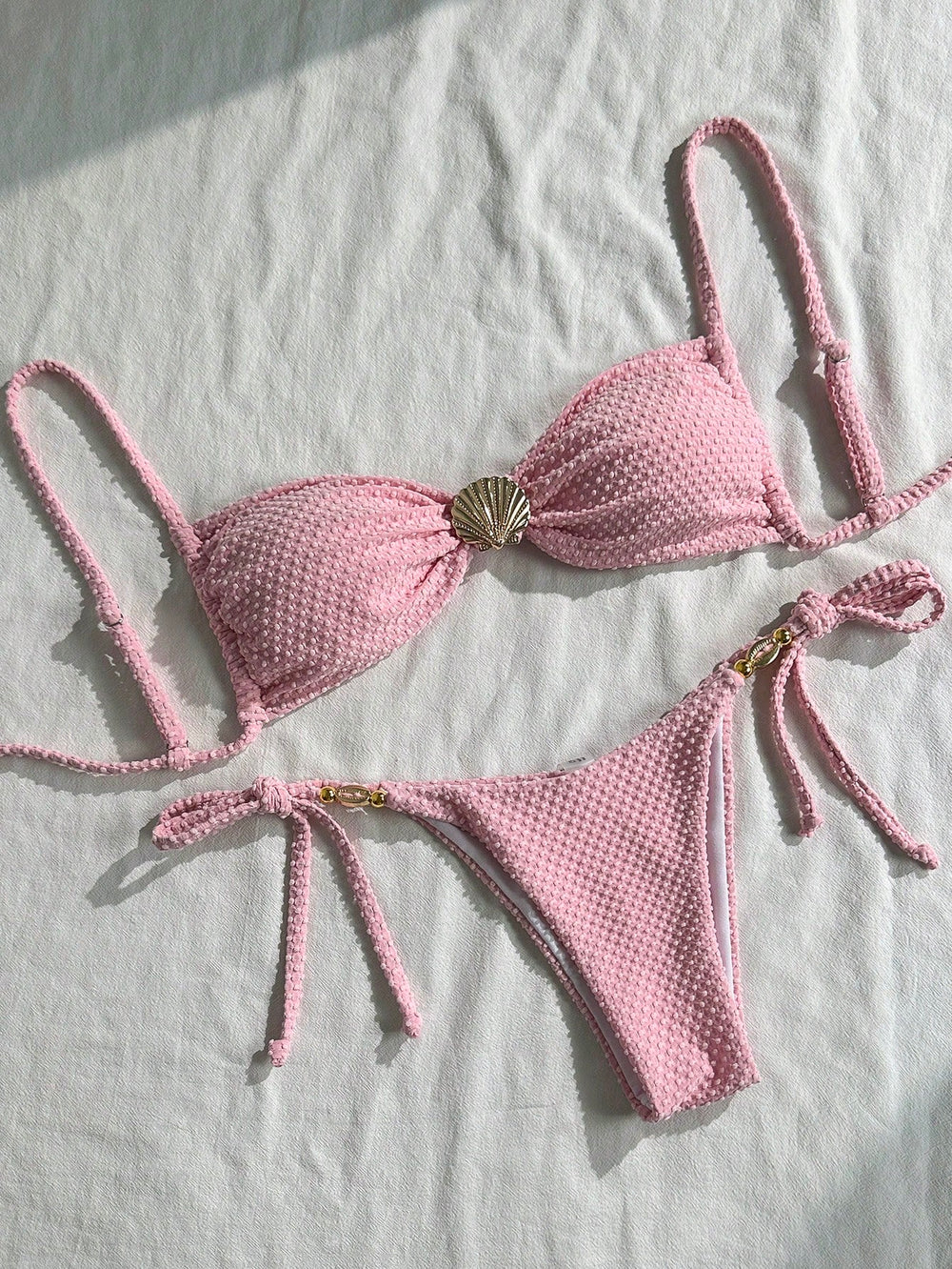 Bikini Rosa Textura set completo con detalle de concha dorada.
