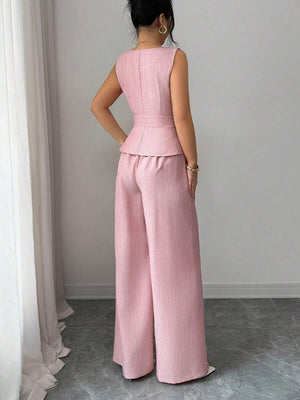 Perfil de la modelo luciendo el conjunto de top peplum y pantalón ancho rosa.