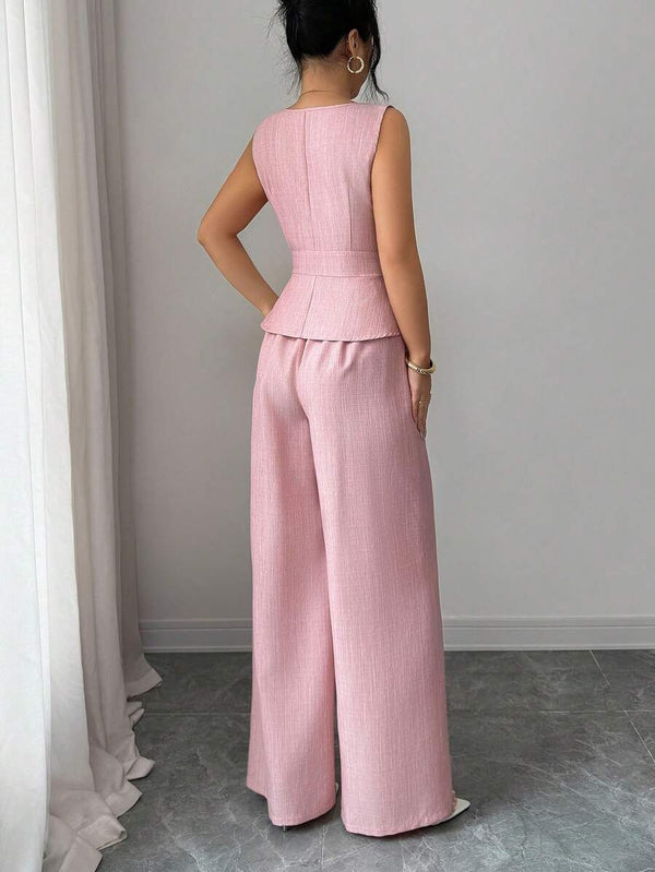 Perfil de la modelo luciendo el conjunto de top peplum y pantalón ancho rosa.