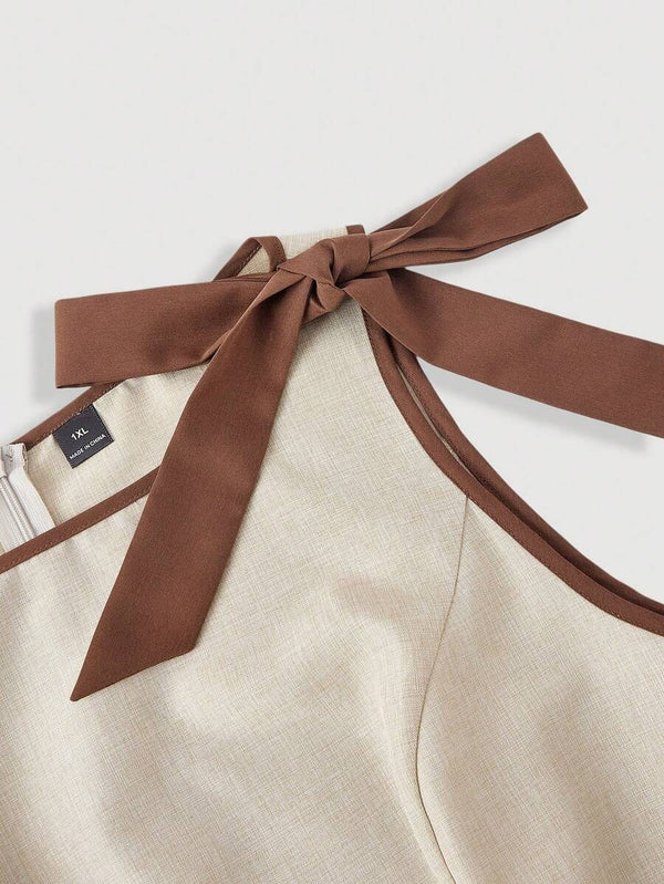 Detalle de la falda corta plisada de un vestido color beige.