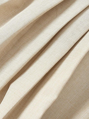 Vista lateral de la falda acampanada y plisada de un vestido corto color beige.
