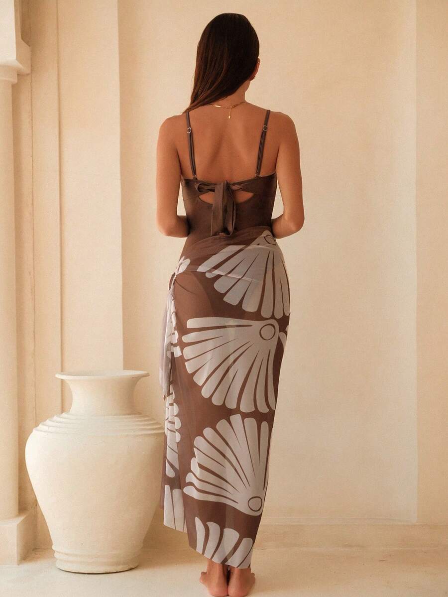 Conjunto de traje de baño entero color café y falda pareo con estampado floral, visto de frente.