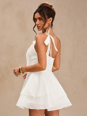 Mujer modelando un elegante vestido asimétrico blanco, ideal para cóctel.