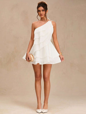 Vista frontal de un vestido corto blanco de un solo hombro con volantes en capas.