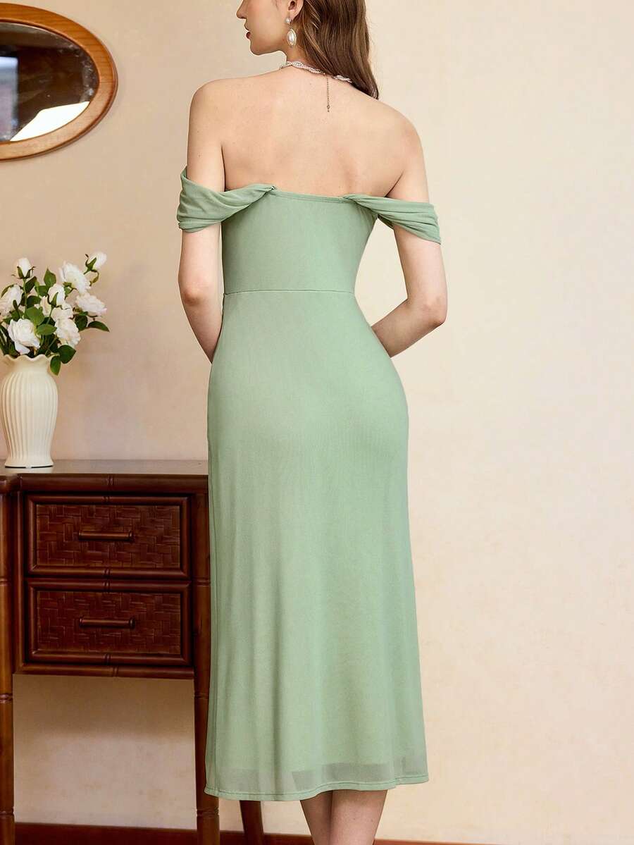 Mujer luciendo un vestido midi elegante color verde menta con hombros descubiertos.
