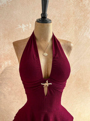Primer plano de la falda con volantes en cascada de un vestido corto color vino.