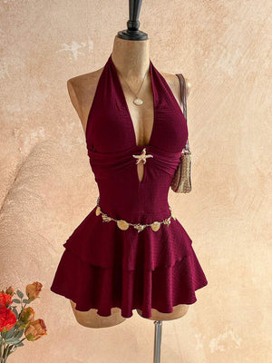 Perfil de un vestido corto halter color vino exhibido en un maniquí.