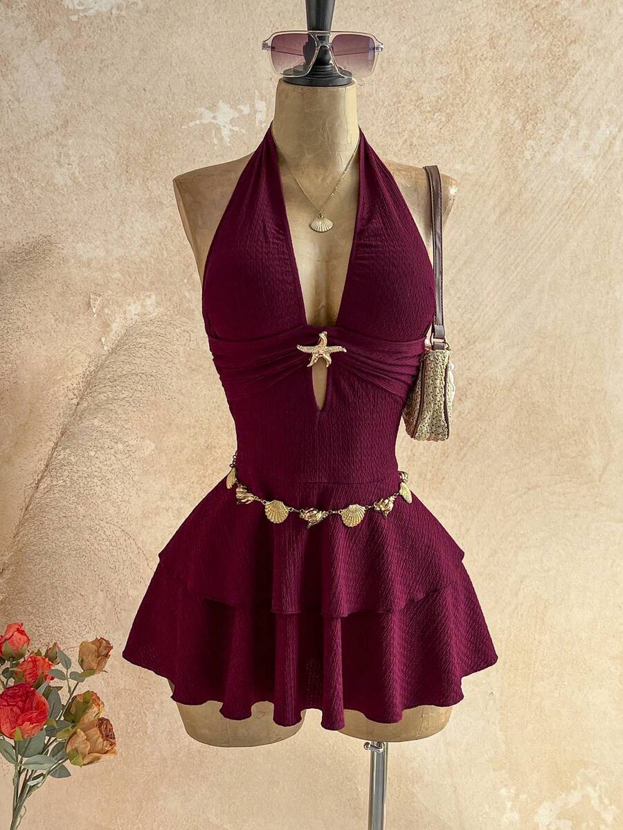 Vista frontal de un vestido corto halter color vino con detalle de estrella de mar y falda de volantes.