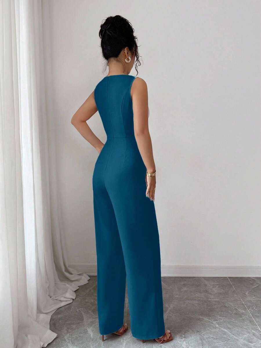 Vista frontal de una mujer luciendo un jumpsuit elegante azul petróleo de pierna ancha y sin mangas con cinturón.