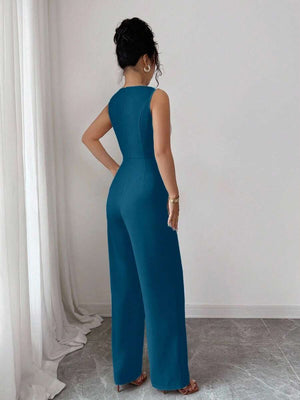 Primer plano del torso de un jumpsuit azul petróleo con cuello barco y cinturón con hebilla rectangular.