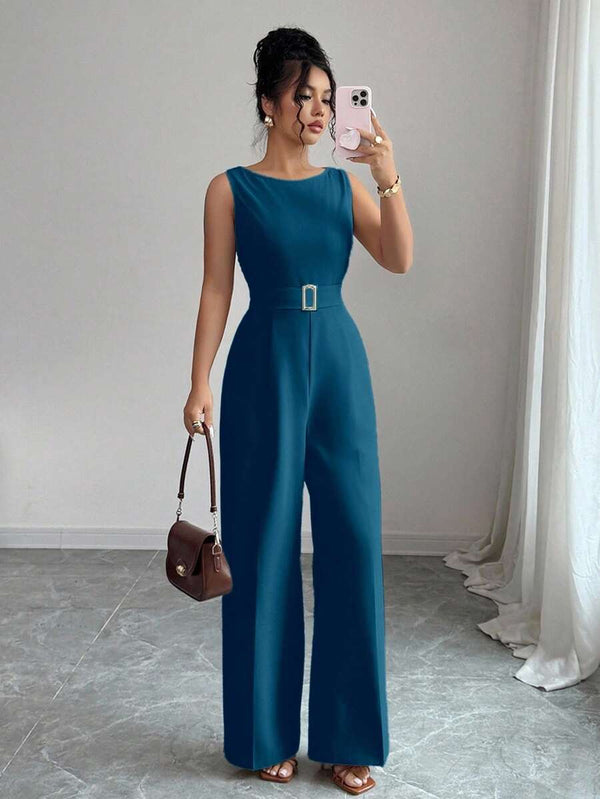 Vista de las piernas anchas y fluidas de un jumpsuit elegante azul petróleo.