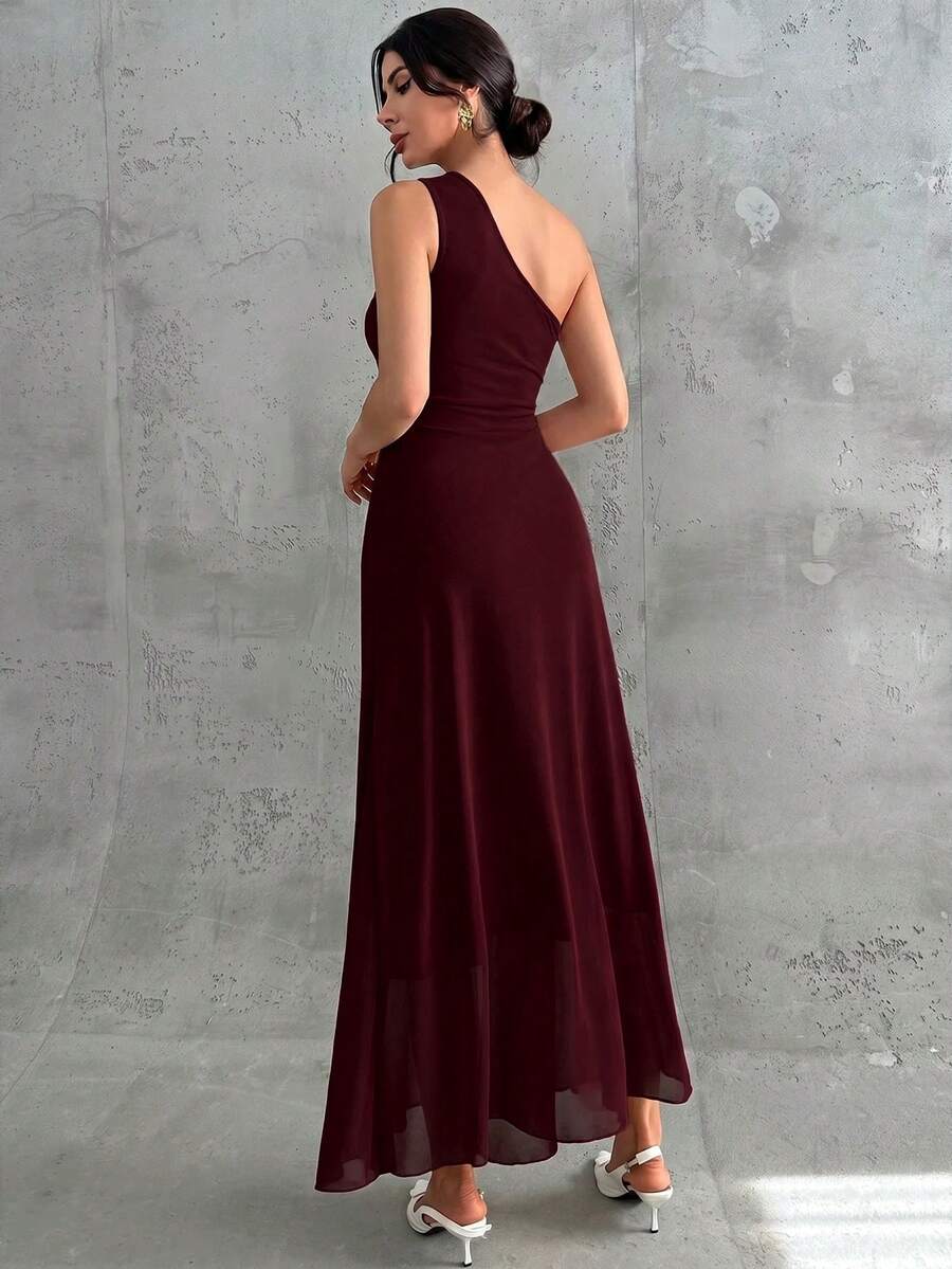 Vista frontal de una mujer usando un vestido largo color vino tinto de un solo hombro con detalle drapeado.