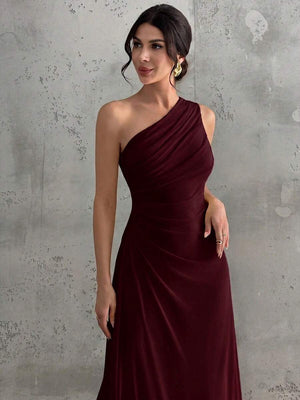 Detalle de la falda larga y fluida de un vestido de noche color vino.