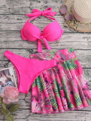Set de bikini rosa con falda de hojas en flat lay.
