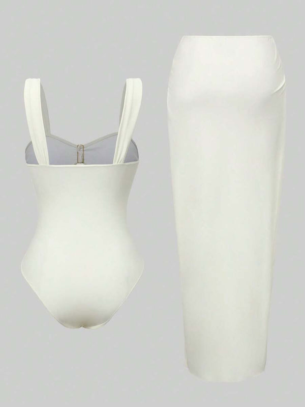 Primer plano del torso de un vestido blanco con tirantes anchos, escote cuadrado y detalles cut-out con botones dorados.