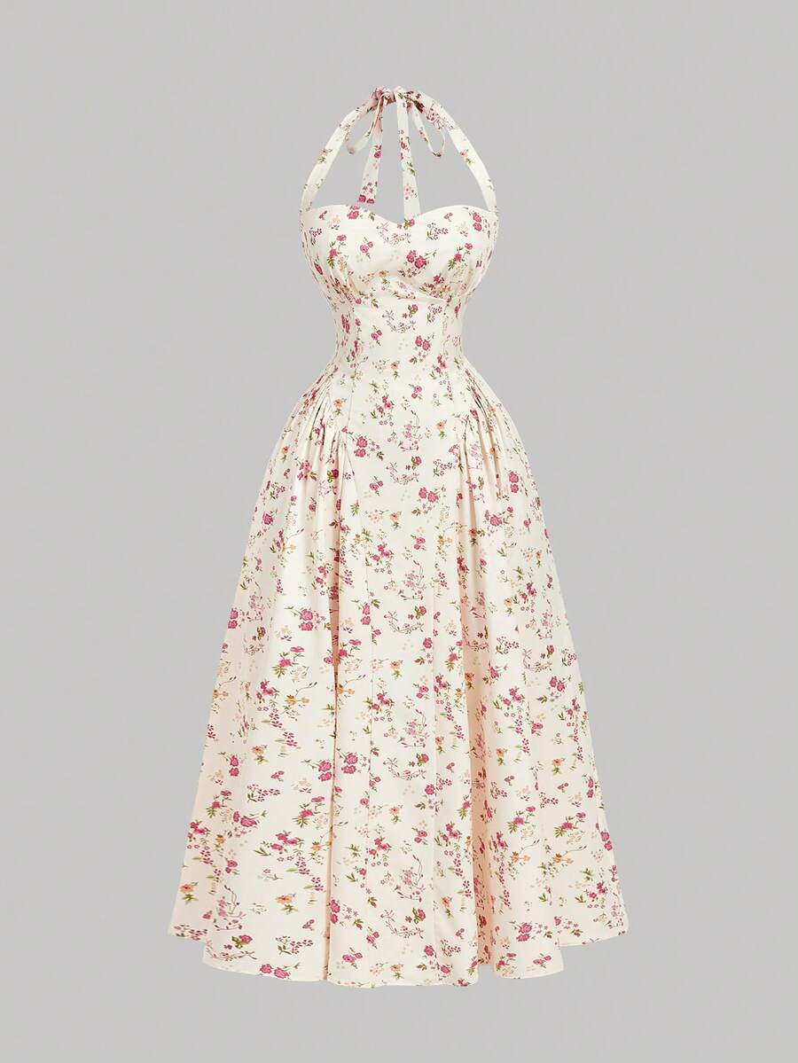 Mujer de espaldas luciendo un vestido floral midi con escote halter en un campo de flores.