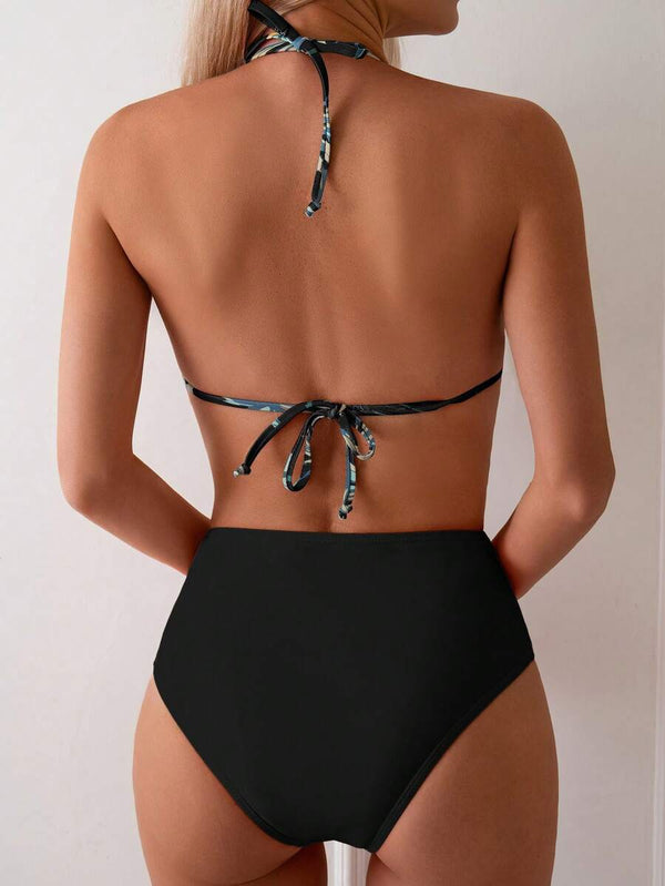 Detalle del top de bikini tipo halter con estampado de hojas tropicales y volante en el borde inferior.