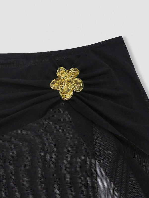 Vista de la cintura de la falda de malla con su aplique floral dorado y abertura.