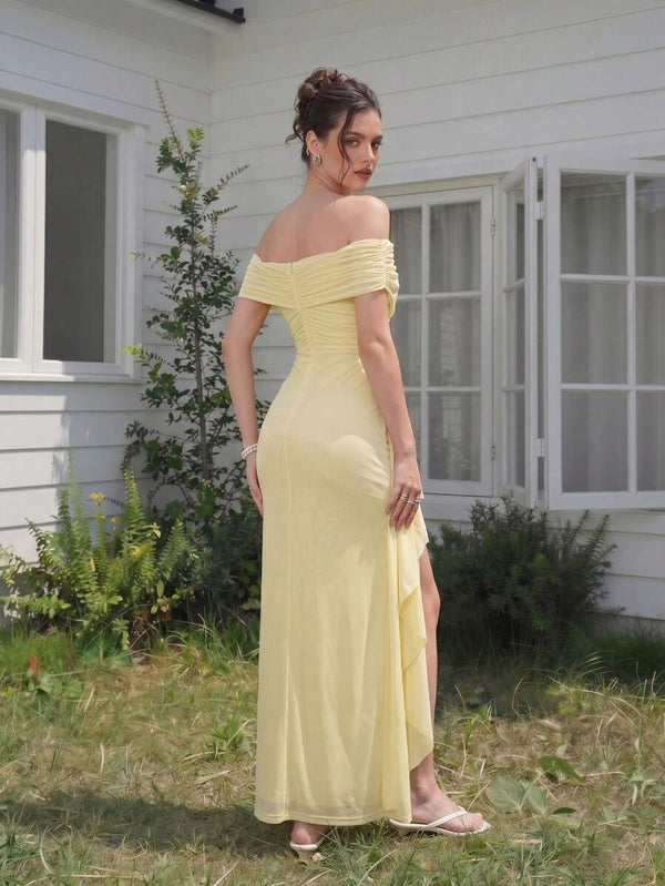 Primer plano del escote de hombros descubiertos de un vestido de fiesta amarillo con detalle fruncido.