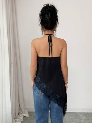 Vista frontal de una modelo usando el top halter negro satinado con jeans.