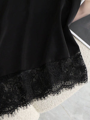 Detalle del lazo y el escote halter del top satinado negro.